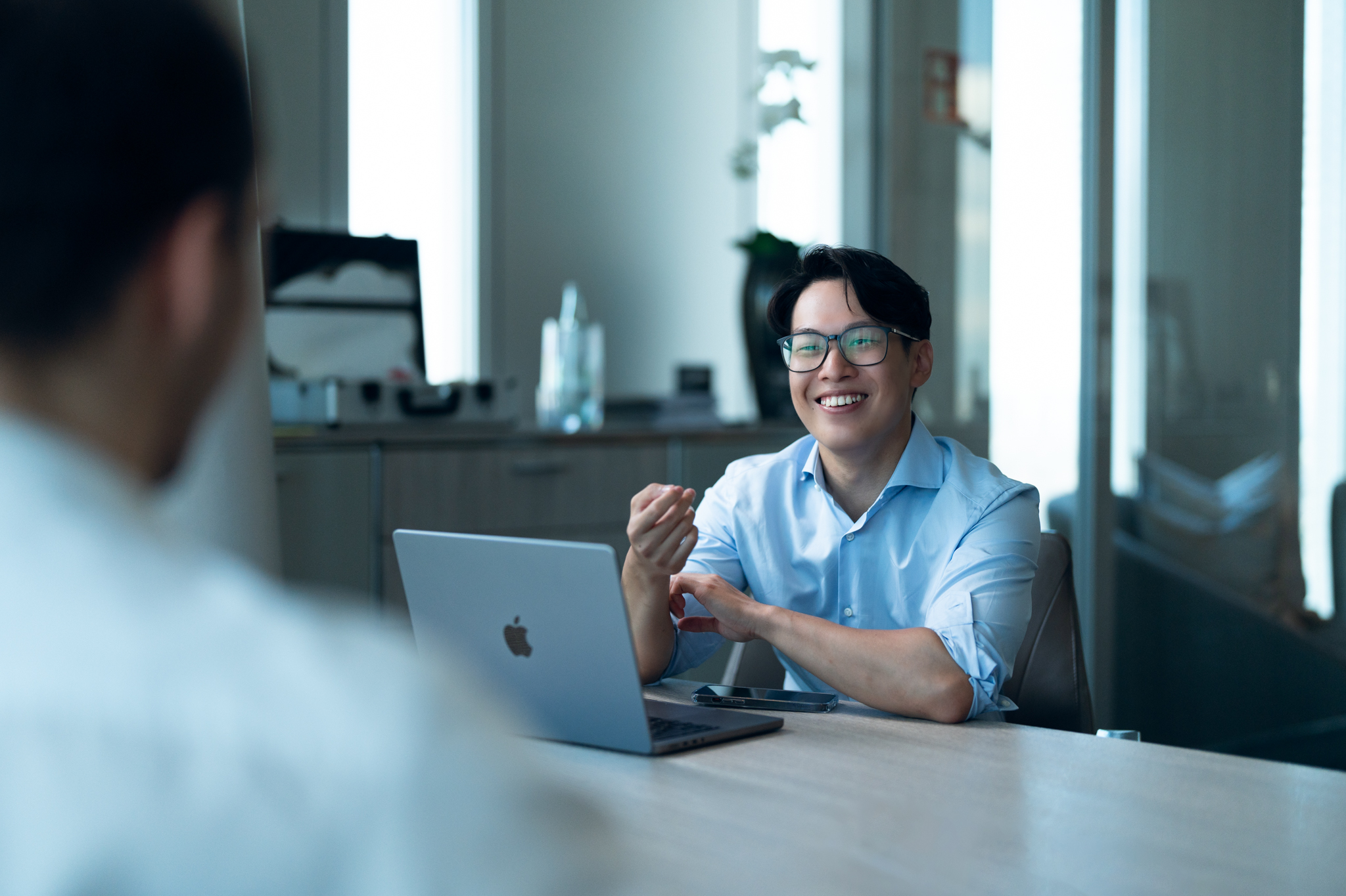 Image of CTO and Founder Jackson Ly sitting in an office talking to a client